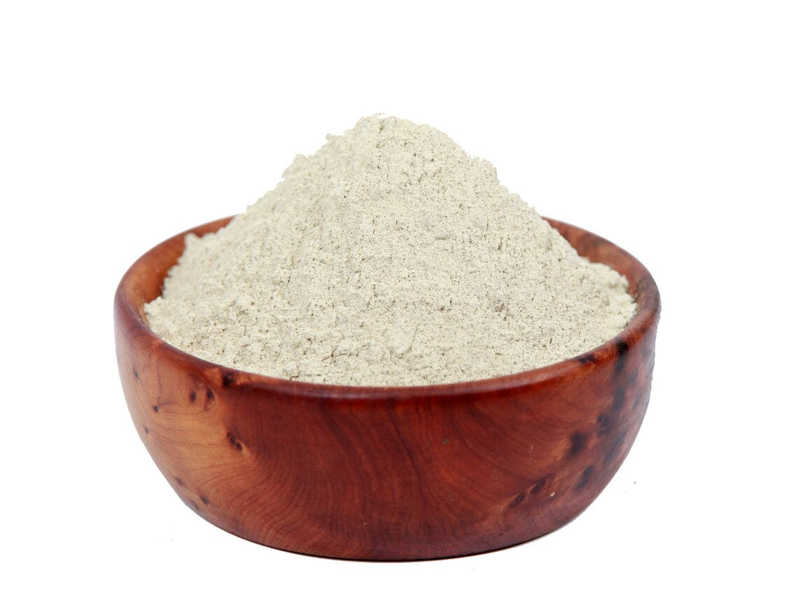 Wooden bowl filled with zeolite clay powder on a white background