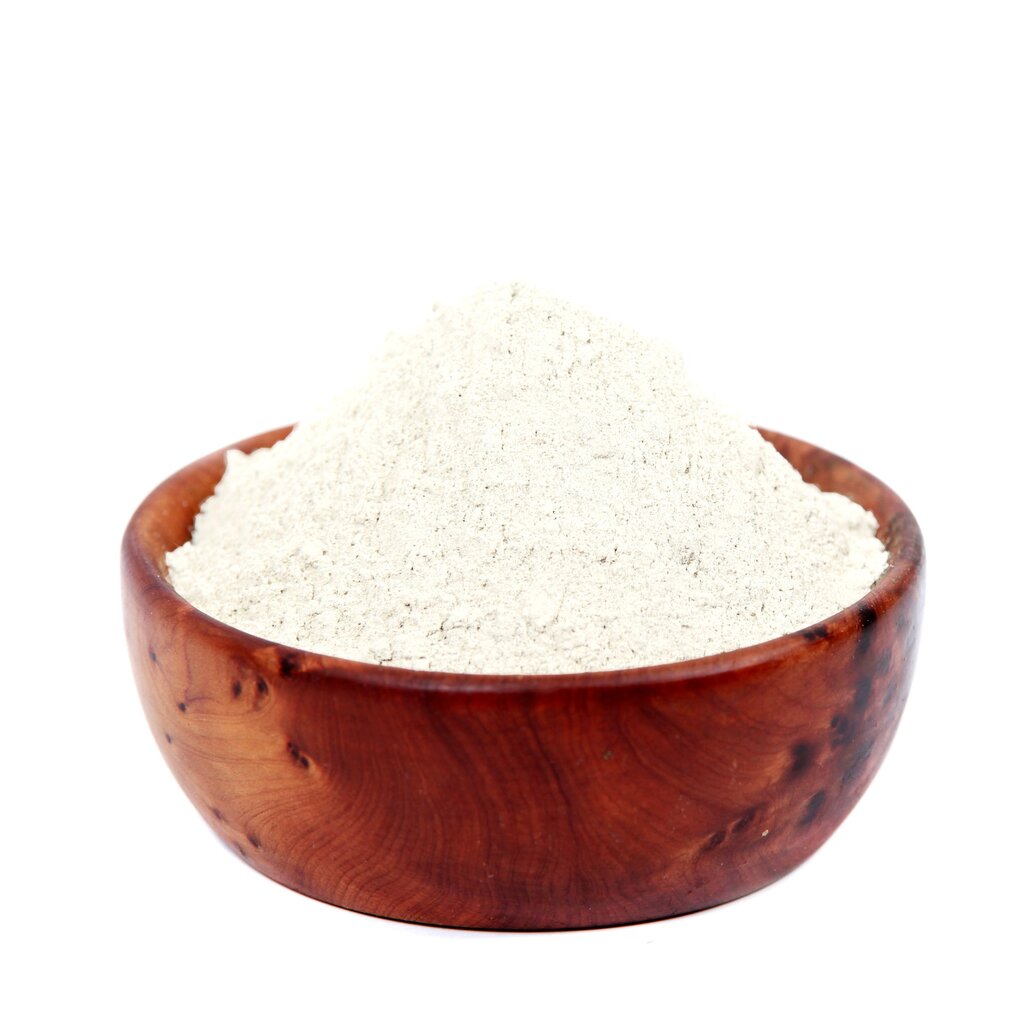 Wooden bowl filled with bentonite clay on a white background