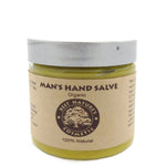 A jar of organic man's hand salve with a label that reads 'Man's Hand Salve, Organic, Best Natures Cosmetic, 100% Natural'. The jar is transparent, showing a yellowish salve inside.